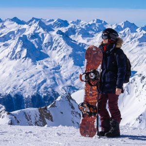 Jessica-met-snowboard-en-besneeuwde-bergen-op-achtergrond