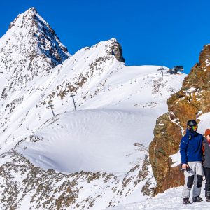 Witte-bergen-blauwe-lucht-stelletje-op-foto