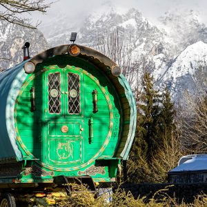 Groene-huifkaf-met-camper-en-bergen-op-achtergrond