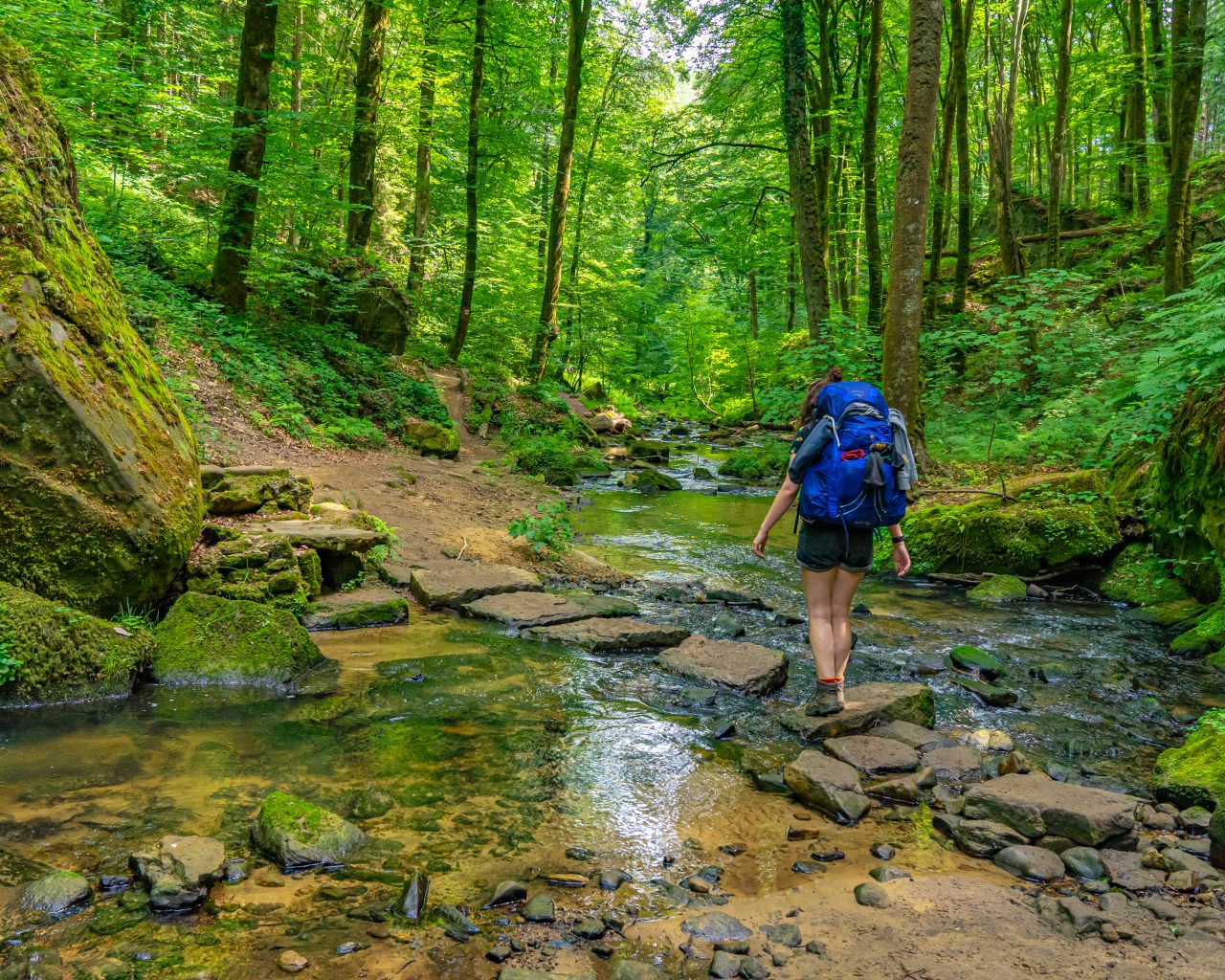 Jessica-steekt-rivier-over-via-stenen-Mullerthal-Trail