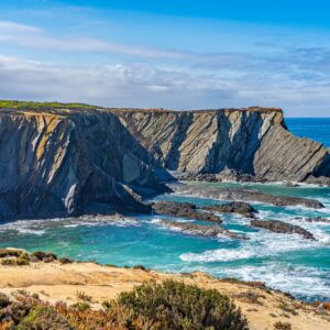 ruige-klif-met-strand-en-blauw-water