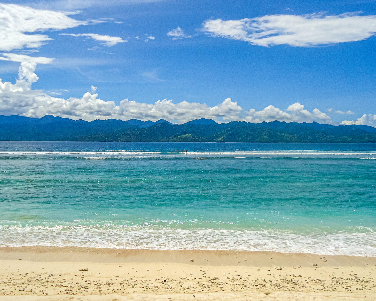 Surfen-gili-trawangan-met-lombok-op-achtergrond