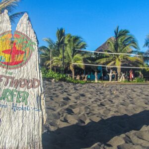 Driftwood-surfer-hostel-bord-op-zwart-strand